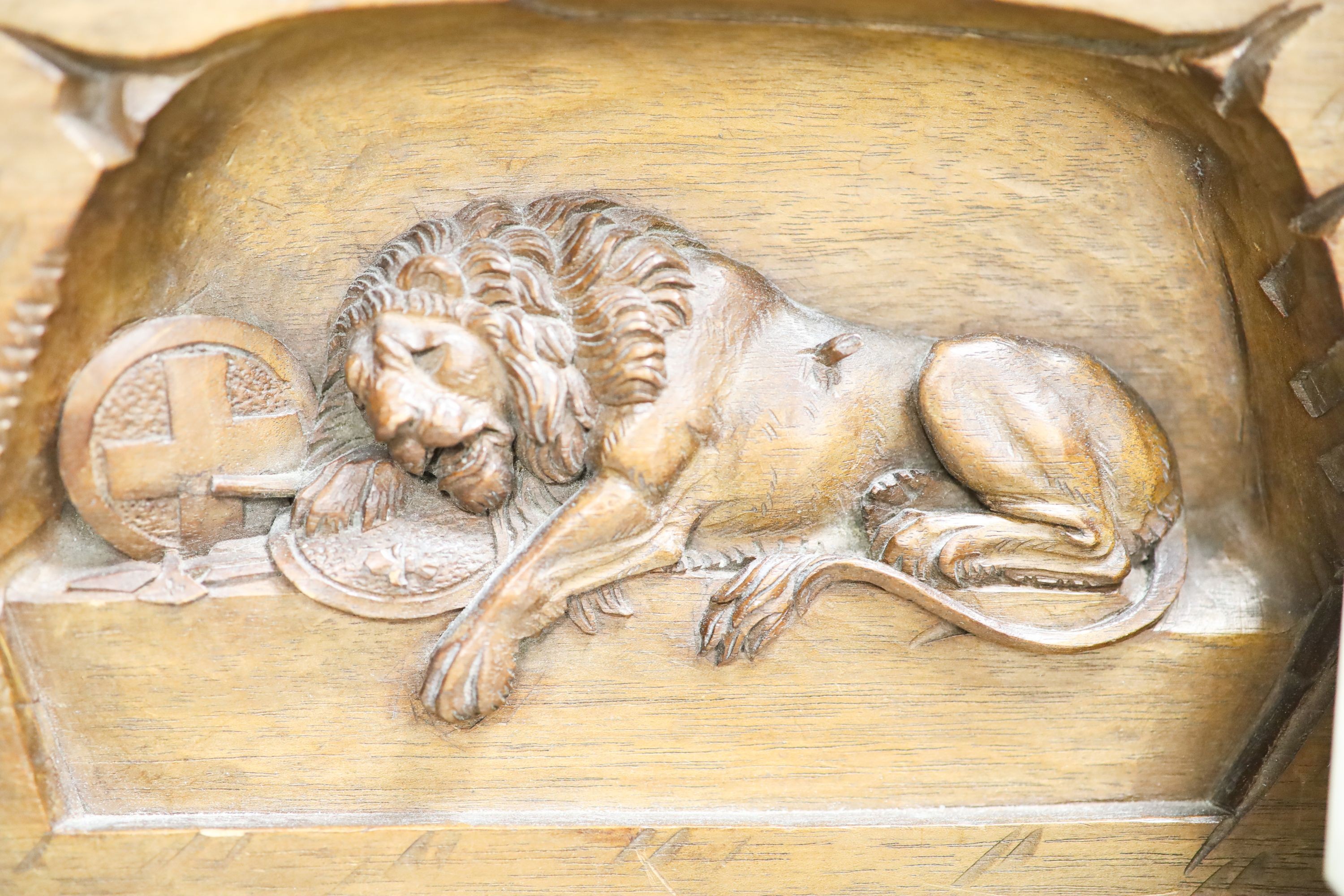 A walnut Lion of Lucerne plaque and carving and an Indian hardstone plaque